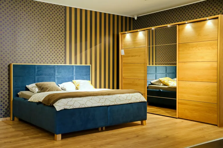 A calm finished bedroom with a bed and fitted wardrobe.